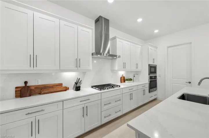 Gas cooktop, large walk-in pantry behind door to right