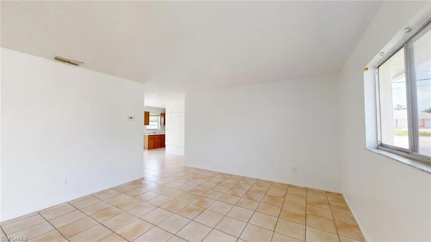 Empty room with light tile patterned floors