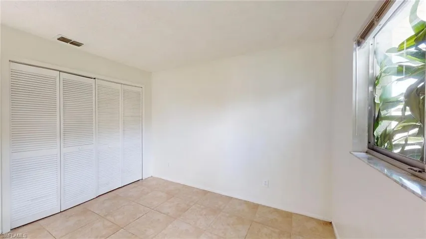 Unfurnished bedroom featuring a closet and light tile patterned floors