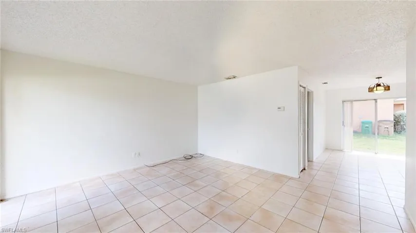 Spare room with a textured ceiling and light tile patterned floors