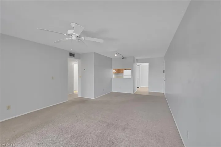 Unfurnished living room with light carpet, ceiling fan, and track lighting