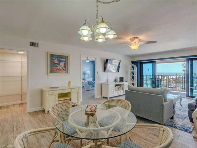 Dining area featuring ceiling fan with notable chandelier and light wood-type flooring