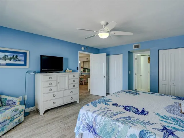 Bedroom featuring multiple closets, ceiling fan, and light hardwood / wood-style flooring