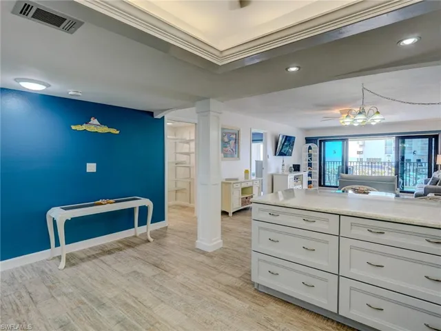 Kitchen featuring decorative light fixtures, light hardwood / wood-style flooring, and decorative columns