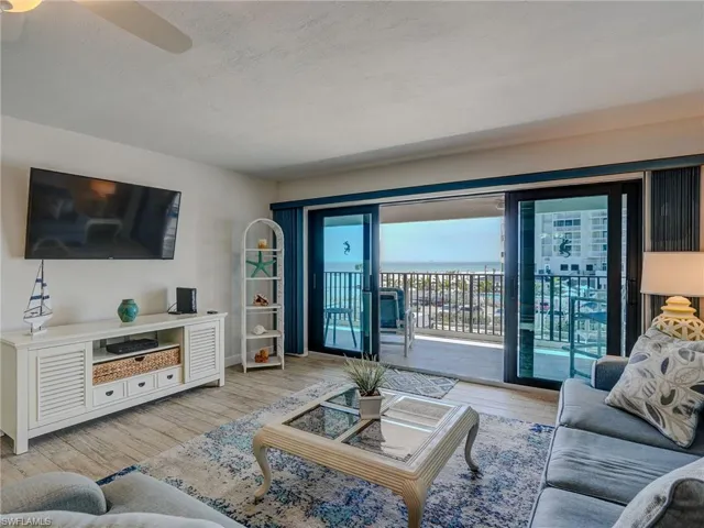 Living room featuring ceiling fan, a textured ceiling, and light hardwood / wood-style floors