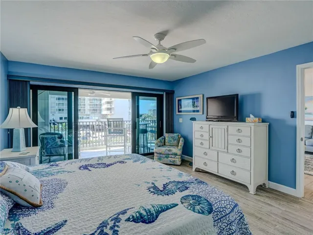 Bedroom with ceiling fan, light wood-type flooring, a textured ceiling, and access to outside