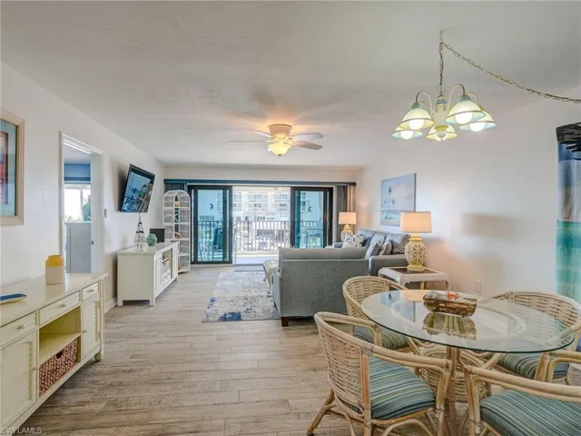Dining space featuring ceiling fan with notable chandelier, a wealth of natural light, and light hardwood / wood-style floors