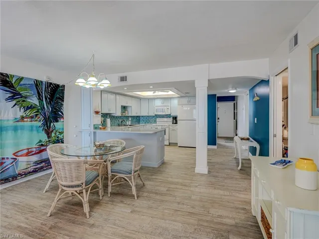 Dining room featuring sink, an inviting chandelier, and light hardwood / wood-style flooring