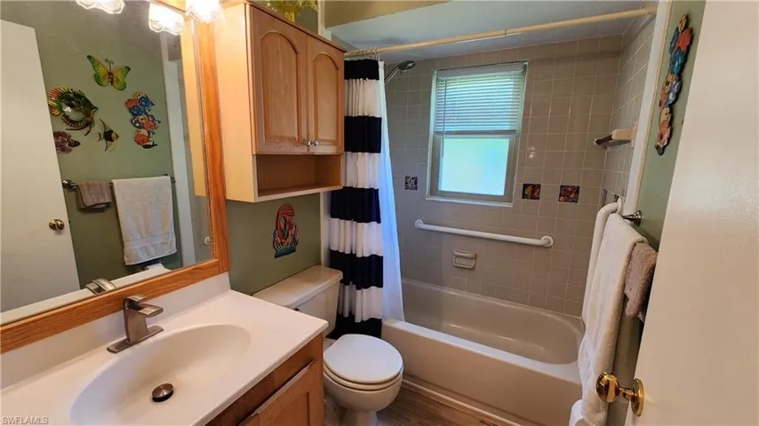 Full bathroom with shower / bath combination with curtain, toilet, and large vanity