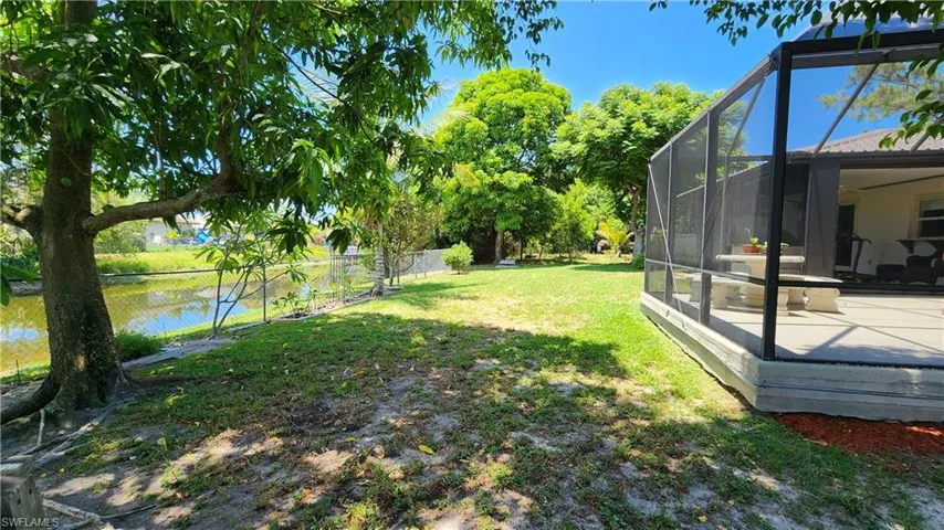 View of yard featuring glass enclosure and a water view