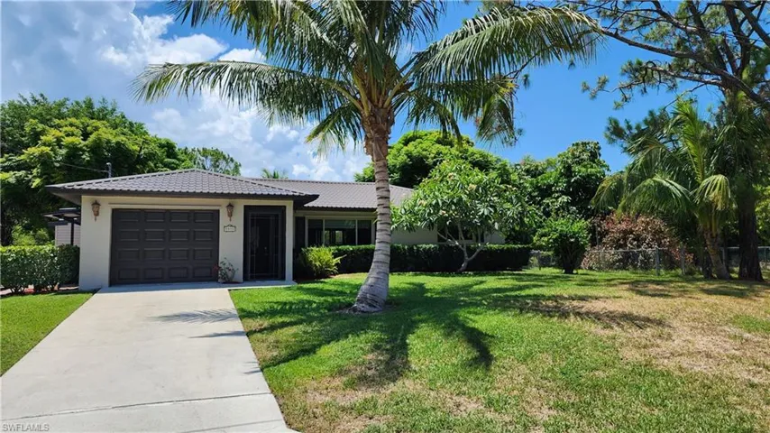 View of front of house featuring a garage and a front lawn