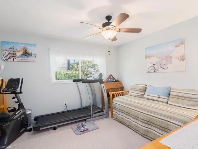 Carpeted bedroom featuring a ceiling fan