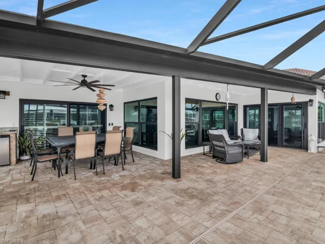 View of patio / terrace featuring a ceiling fan, outdoor dining space, and a lanai