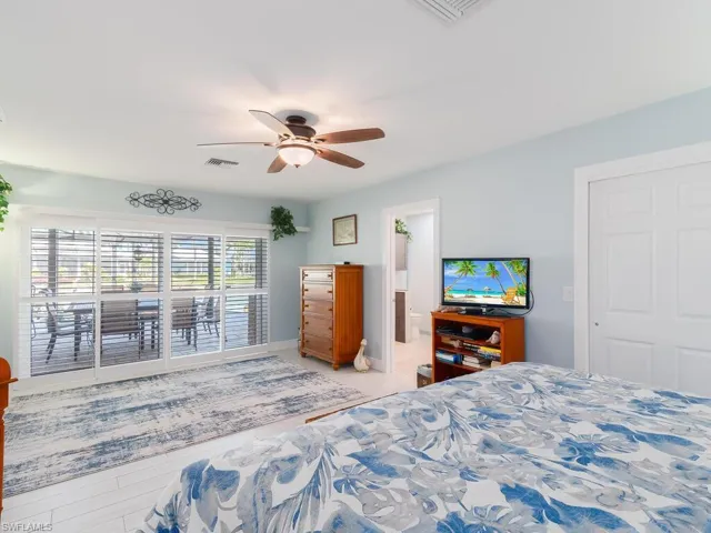 Bedroom with ceiling fan, connected bathroom, and baseboards