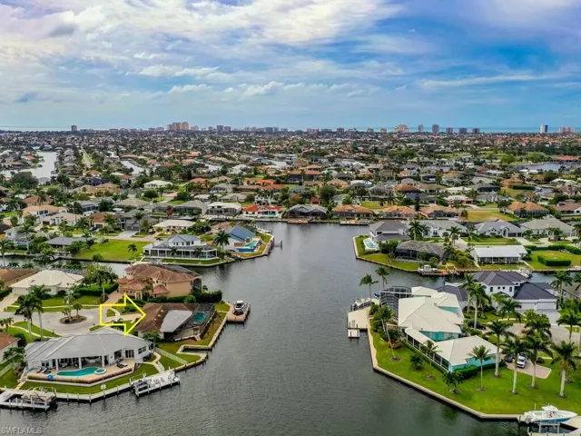 Aerial perspective of suburban area featuring a large body of water and skyline