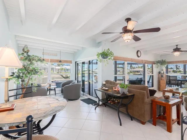 Sunroom with tile patterned flooring and beam ceiling
