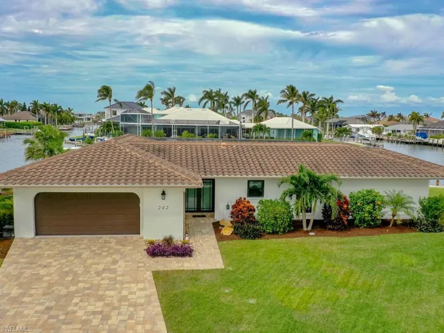 Single story home with a tile roof, a front lawn, a garage, and stucco siding
