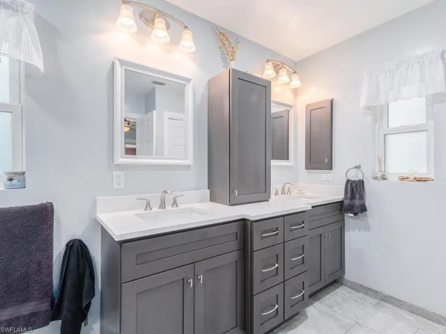 Bathroom with double vanity and baseboards