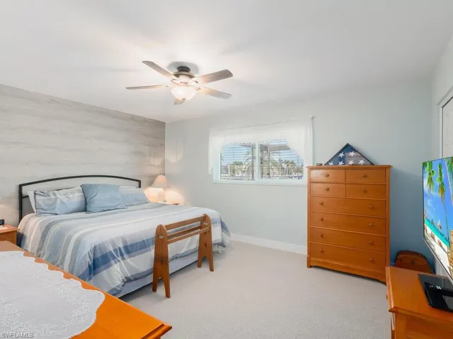 Carpeted bedroom featuring baseboards and ceiling fan