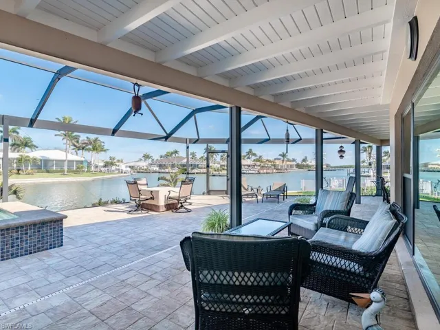 View of patio featuring a water view, a lanai, an outdoor living space, and outdoor dining area