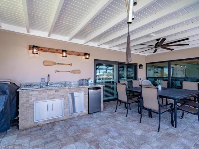 View of patio / terrace featuring a sink, a ceiling fan, area for grilling, and outdoor dining area