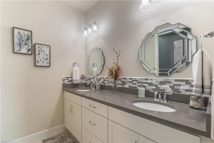Bathroom featuring tasteful backsplash and vanity