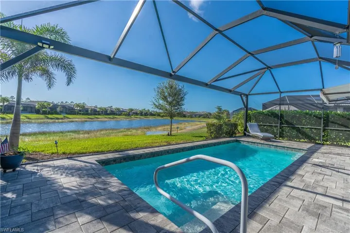 View of pool with a water view, a patio area, and a lanai