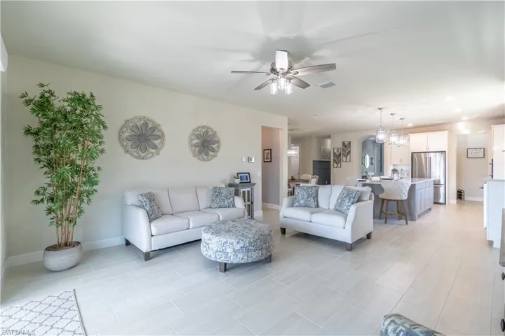 Living room with ceiling fan with notable chandelier