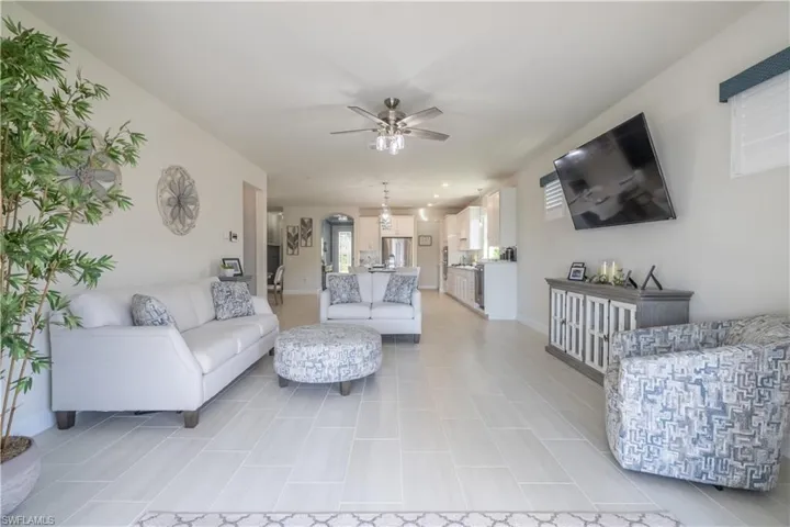 Living room featuring light tile patterned floors and ceiling fan