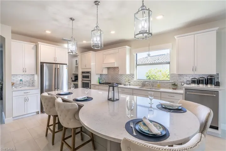 Kitchen featuring white cabinets, a kitchen island, and hanging light fixtures