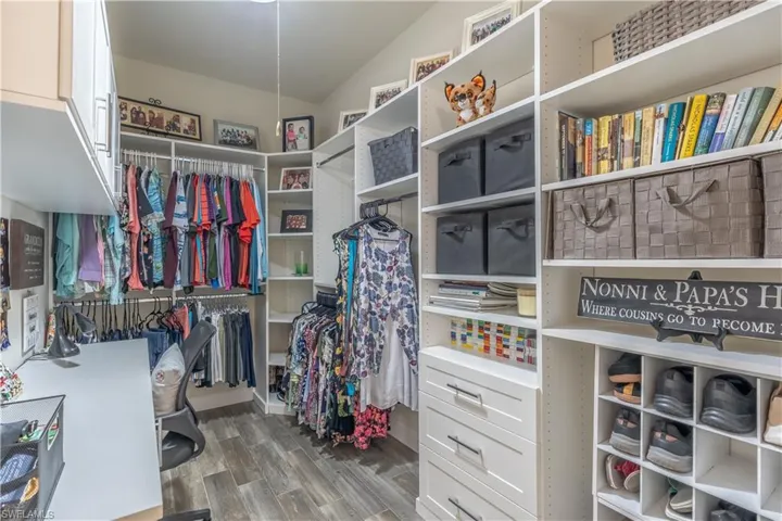 Spacious closet with hardwood / wood-style flooring and lofted ceiling