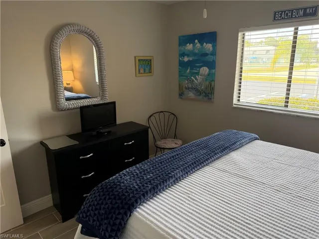 Bedroom featuring baseboards and wood tiled floors