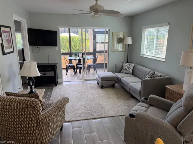 Living area with wood finish floors, ceiling fan, and plenty of natural light