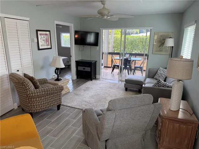 Living area featuring ceiling fan, wood tiled floors, and plenty of natural light