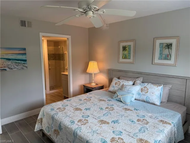 Bedroom with ensuite bath, ceiling fan, and wood tiled floors