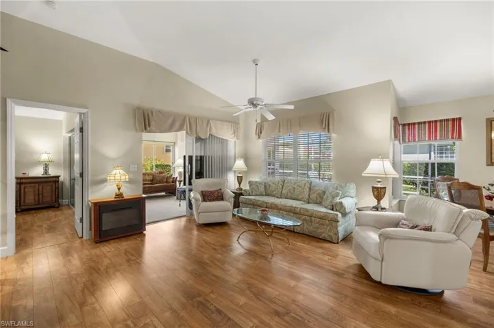 Living area featuring lofted ceiling, wood finished floors, and ceiling fan