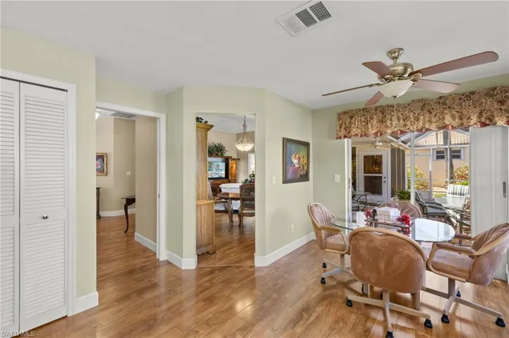 Dining space featuring ceiling fan, visible vents, baseboards, and wood finished floors