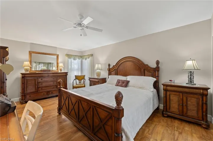 Bedroom featuring ceiling fan, baseboards, and wood finished floors