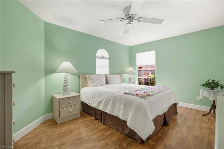 Bedroom with light wood-style flooring, baseboards, and ceiling fan