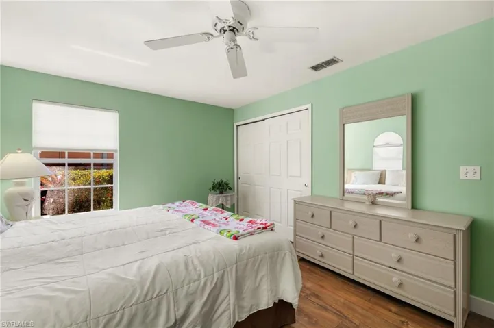 Bedroom featuring a closet, visible vents, ceiling fan, and dark wood-style flooring