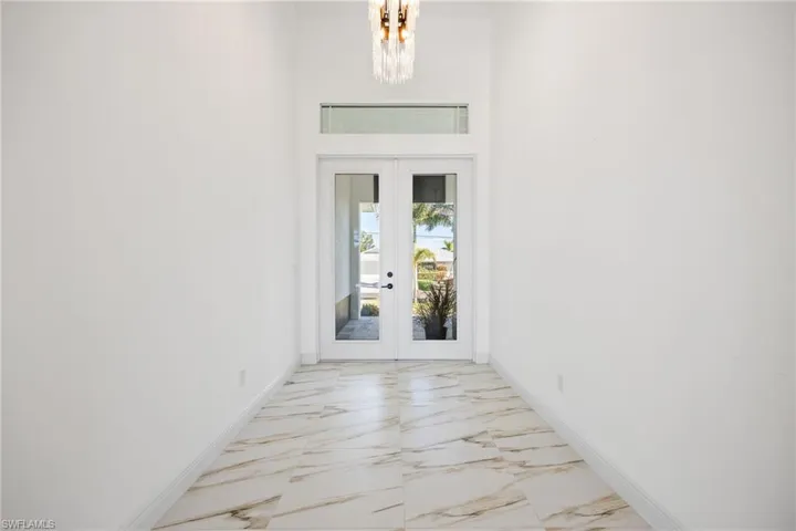View of exterior entry featuring stucco siding and french doors