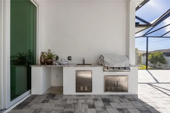 View of patio / terrace with exterior kitchen, a lanai, and a sunroom
