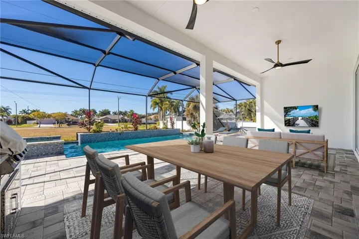 AI Staged photo.  View of patio featuring a ceiling fan, a sunroom, a lanai, outdoor dining space, and grilling area