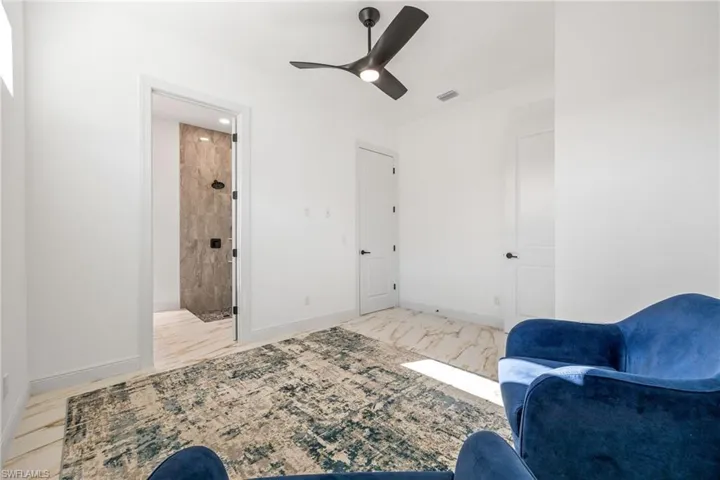 Sitting room featuring light marble finish floors and ceiling fan