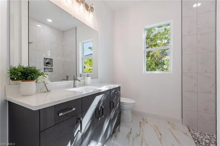 Bathroom with vanity and light marble finish floors