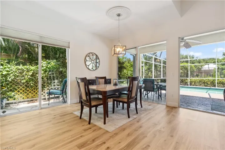 Dining area with plenty of natural light, light hardwood / wood-style flooring, and a notable chandelier