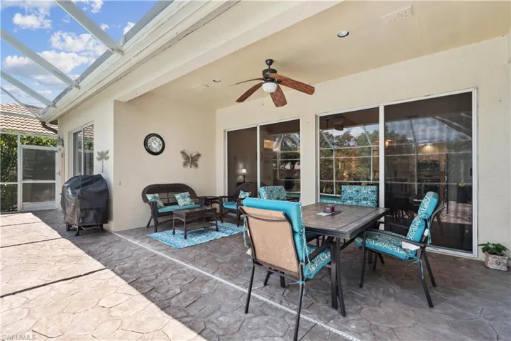 View of terrace featuring a grill, glass enclosure, outdoor lounge area, and ceiling fan