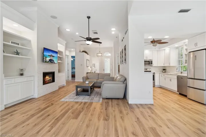 Living room with light hardwood / wood-style floors, a fireplace, and ceiling fan