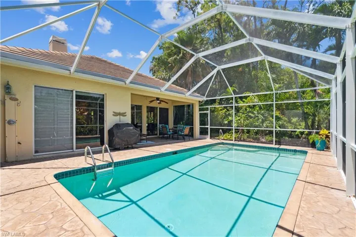 View of pool with a patio, a lanai, ceiling fan, and grilling area