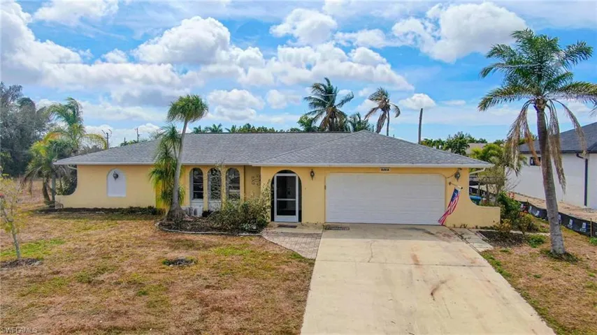 Single story home featuring stucco siding, driveway, a garage, a shingled roof, and a front lawn